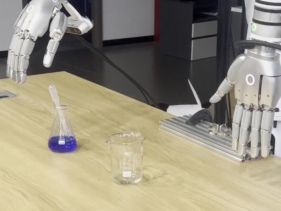 A five-finger robotic hand open above an Erlenmeyer flask of blue liquid on a lab bench