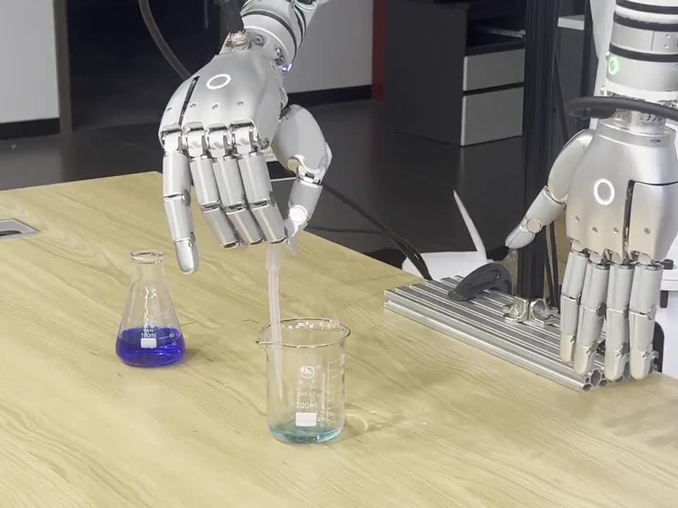 The hand holding the pipette with its tip inside an empty glass beaker